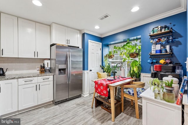 71 Sudbury Sq, Sterling, VA 20164 - kitchen featuring stainless steel fridge with ice dispenser, crown molding, light wood-style flooring, white cabinetry, and wainscoting