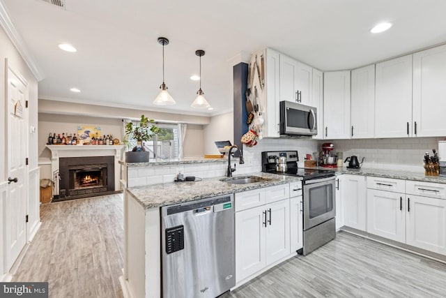 71 Sudbury Sq, Sterling, VA 20164 - kitchen with appliances with stainless steel finishes, a sink, crown molding, white cabinets, and a peninsula
