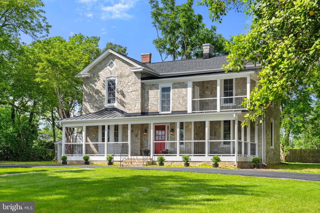 105 E Washington St, Remington, VA 22734 - view of front of property featuring stone siding, a standing seam roof, a chimney, covered porch, and metal roof