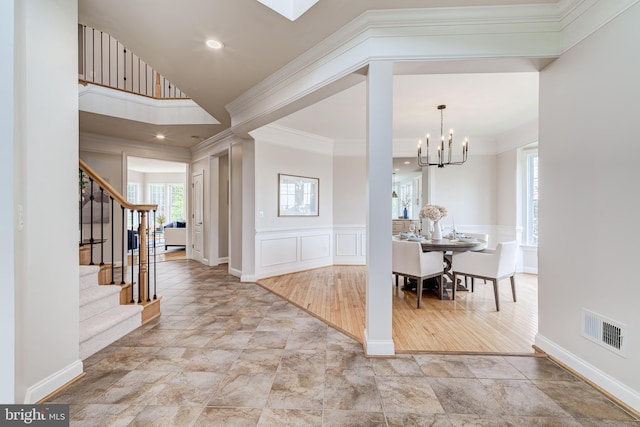 42720 Mount Auburn Pl, Broadlands, VA 20148 - entryway featuring stairway, a decorative wall, crown molding, stone finish flooring, and a chandelier