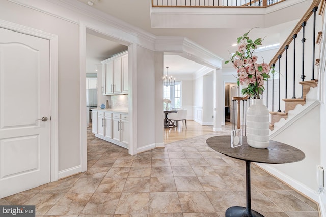 42720 Mount Auburn Pl, Broadlands, VA 20148 - foyer featuring a chandelier, stairs, ornamental molding, and baseboards