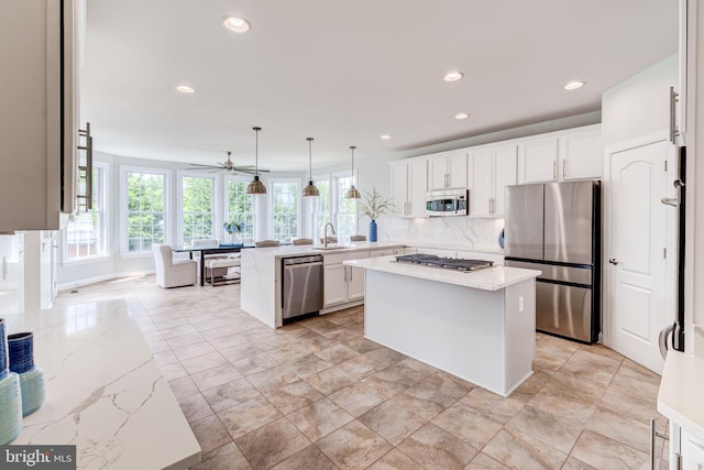42720 Mount Auburn Pl, Broadlands, VA 20148 - kitchen with stainless steel appliances, a peninsula, white cabinetry, recessed lighting, and decorative backsplash