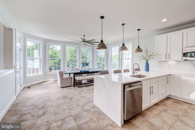 42720 Mount Auburn Pl, Broadlands, VA 20148 - kitchen featuring a sink, appliances with stainless steel finishes, white cabinetry, a peninsula, and light stone counters