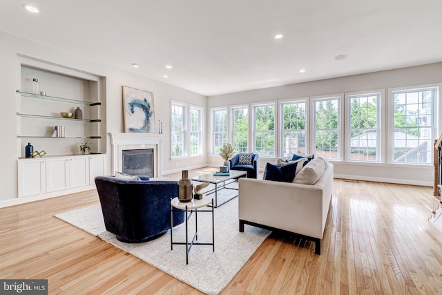 42720 Mount Auburn Pl, Broadlands, VA 20148 - living area featuring light wood finished floors, a glass covered fireplace, recessed lighting, and baseboards