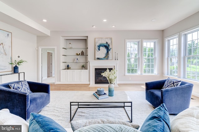 42720 Mount Auburn Pl, Broadlands, VA 20148 - living room featuring wood finished floors, built in shelves, recessed lighting, baseboards, and a fireplace with flush hearth