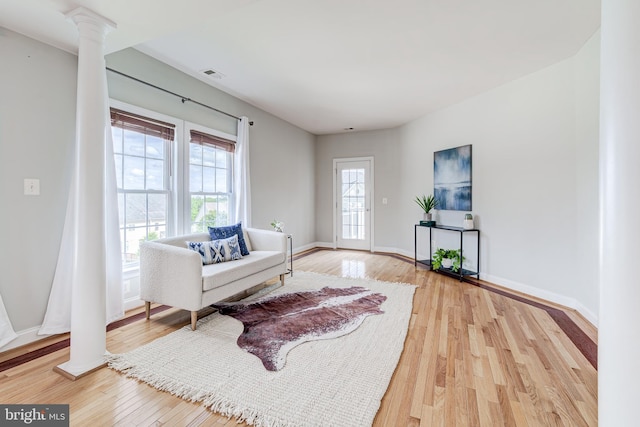 42720 Mount Auburn Pl, Broadlands, VA 20148 - living area with decorative columns, light wood-style floors, and baseboards