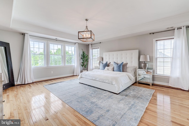 42720 Mount Auburn Pl, Broadlands, VA 20148 - bedroom featuring a tray ceiling, baseboards, a chandelier, light wood-style floors, and crown molding