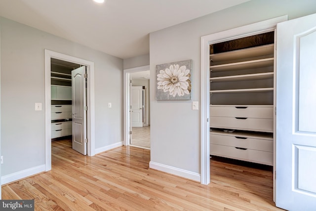 42720 Mount Auburn Pl, Broadlands, VA 20148 - unfurnished bedroom with a walk in closet, a closet, light wood-type flooring, and baseboards