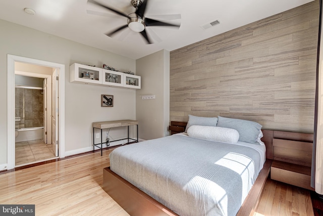 42720 Mount Auburn Pl, Broadlands, VA 20148 - bedroom featuring an accent wall, wood finished floors, wooden walls, baseboards, and ceiling fan