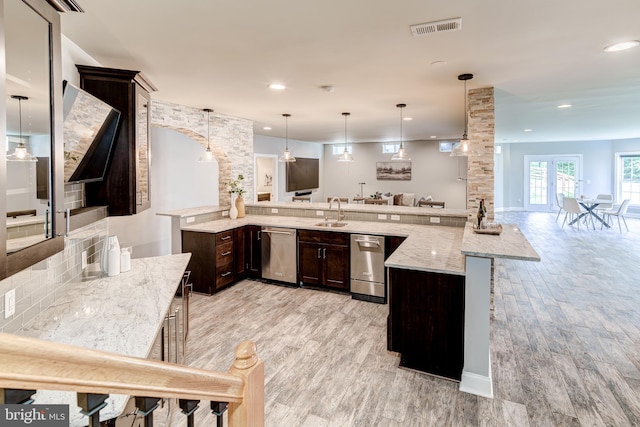 42720 Mount Auburn Pl, Broadlands, VA 20148 - kitchen with stainless steel dishwasher, ornate columns, dark brown cabinetry, light wood-type flooring, and a sink