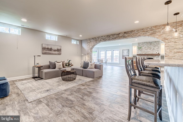 42720 Mount Auburn Pl, Broadlands, VA 20148 - living room with arched walkways, plenty of natural light, recessed lighting, baseboards, and wood finished floors