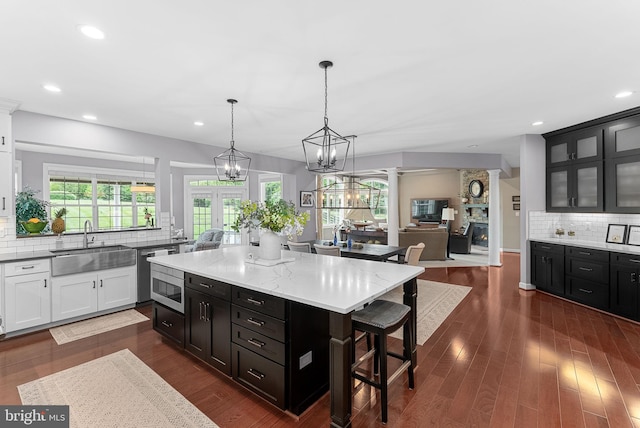 22415 Conservancy Dr, Ashburn, VA 20148 - kitchen featuring a sink, a kitchen bar, dark cabinets, backsplash, and recessed lighting