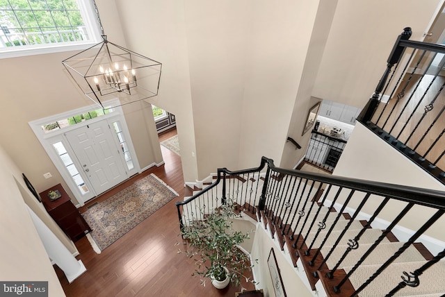 22415 Conservancy Dr, Ashburn, VA 20148 - foyer with a towering ceiling, wood finished floors, a chandelier, stairway, and baseboards