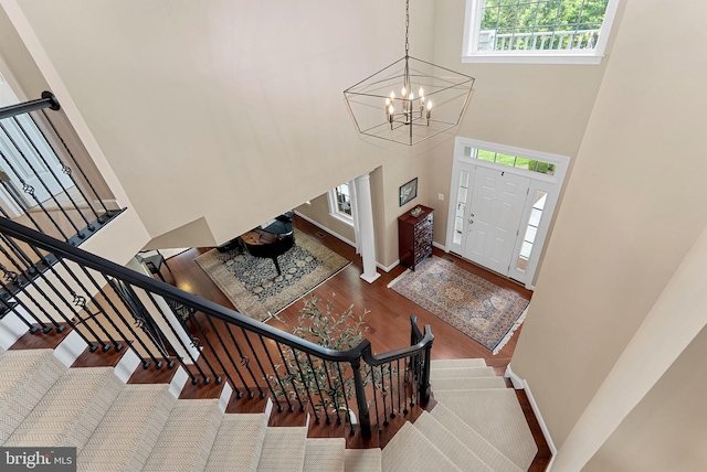22415 Conservancy Dr, Ashburn, VA 20148 - entryway featuring a towering ceiling, baseboards, stairs, wood finished floors, and a chandelier