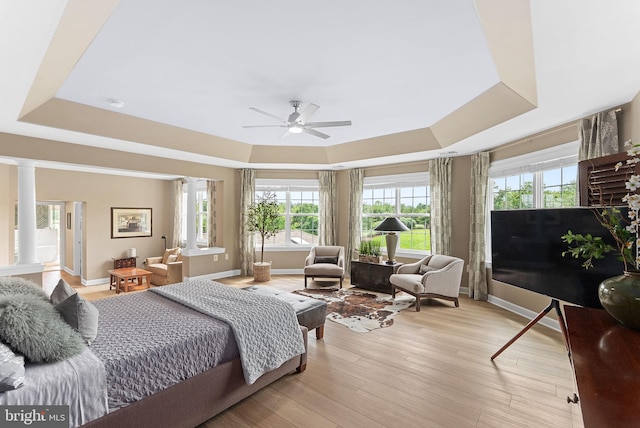 22415 Conservancy Dr, Ashburn, VA 20148 - bedroom with a raised ceiling, ornate columns, baseboards, and light wood-type flooring