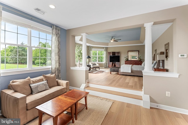 22415 Conservancy Dr, Ashburn, VA 20148 - living room with decorative columns, a raised ceiling, wood finished floors, a ceiling fan, and baseboards