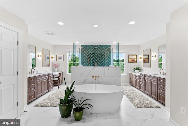22415 Conservancy Dr, Ashburn, VA 20148 - bathroom with marble finish floors, a soaking tub, two vanities, healthy amount of natural light, and recessed lighting