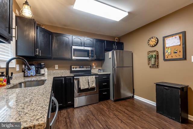 15245 Wedgewood Dr, Greencastle, PA 17225 - kitchen featuring appliances with stainless steel finishes, a sink, dark wood-type flooring, light stone counters, and baseboards
