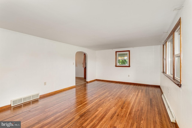 335 Bolton Ave, Carlisle, PA 17013 - empty room featuring baseboard heating, arched walkways, wood finished floors, and baseboards