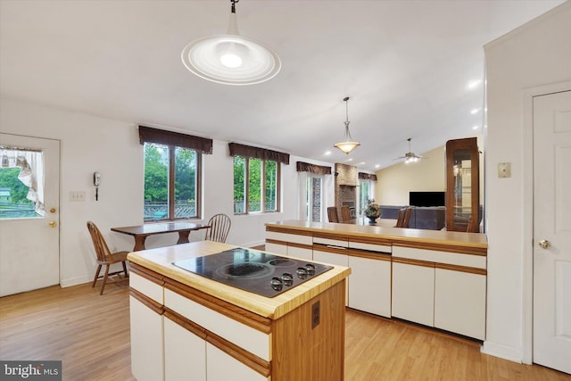 8292 Hickory Rd, Stewartstown, PA 17363 - kitchen with black electric cooktop, light wood finished floors, white cabinetry, ceiling fan, and pendant lighting