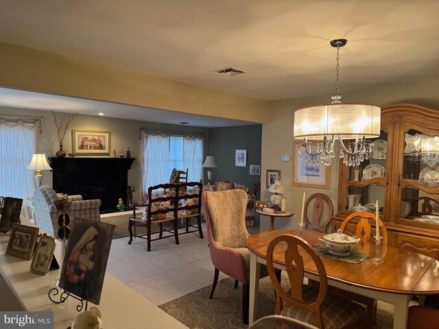 3001 E Chestnut Ave Unit G62, Vineland, NJ 08361 - carpeted dining area with a chandelier and a fireplace with raised hearth