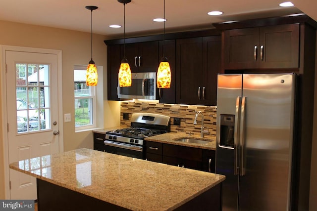 1317 Winston Ave, Baltimore, MD 21239 - kitchen with appliances with stainless steel finishes, dark brown cabinetry, tasteful backsplash, a center island, and decorative light fixtures