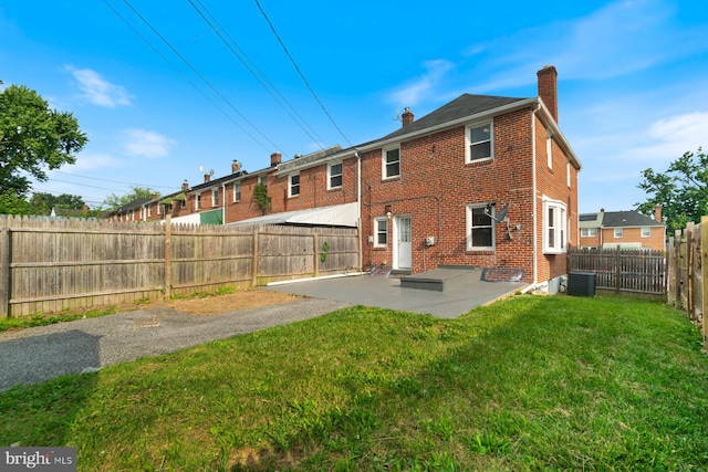 1317 Winston Ave, Baltimore, MD 21239 - rear view of house with a chimney, brick siding, a patio area, and a fenced backyard