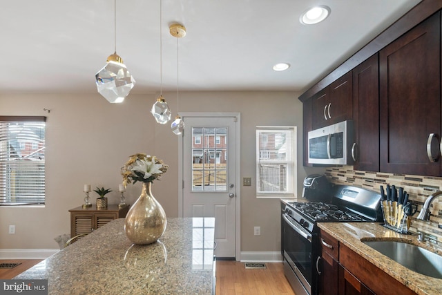 1317 Winston Ave, Baltimore, MD 21239 - kitchen featuring stainless steel appliances, healthy amount of natural light, decorative backsplash, light wood-type flooring, and recessed lighting