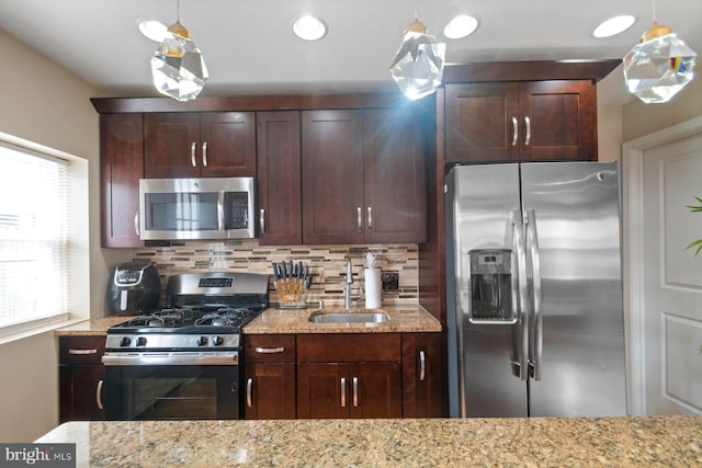 1317 Winston Ave, Baltimore, MD 21239 - kitchen featuring appliances with stainless steel finishes, tasteful backsplash, light stone countertops, dark brown cabinetry, and pendant lighting