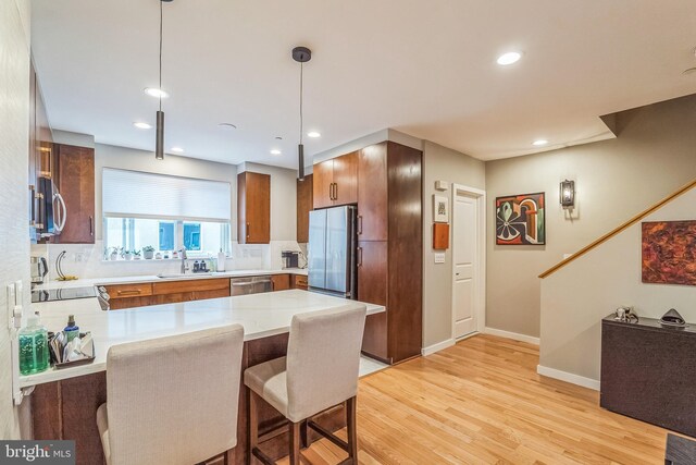 211 Brown St Unit 15, Philadelphia, PA 19123 - kitchen featuring appliances with stainless steel finishes, a sink, a peninsula, light wood-style flooring, and recessed lighting