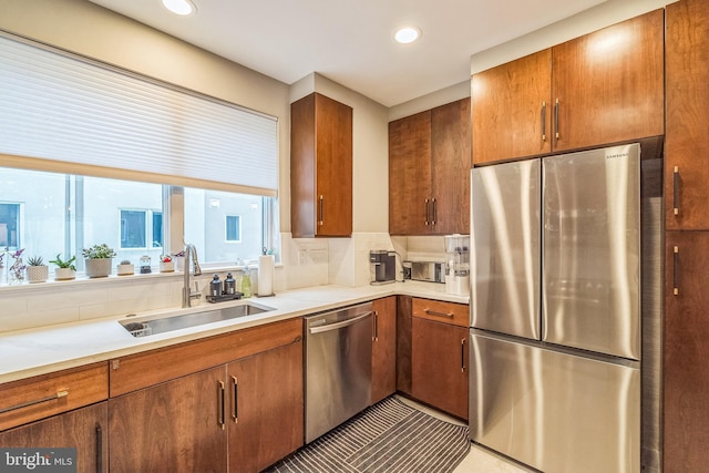 211 Brown St Unit 15, Philadelphia, PA 19123 - kitchen with appliances with stainless steel finishes, a sink, brown cabinetry, recessed lighting, and light countertops