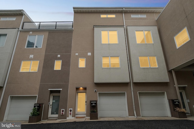 211 Brown St Unit 15, Philadelphia, PA 19123 - view of property featuring stucco siding and a garage