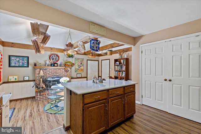 15 Hamilton Ct, Lawrenceville, NJ 08648 - kitchen featuring wood finished floors, light countertops, a fireplace, a kitchen island, and a wainscoted wall