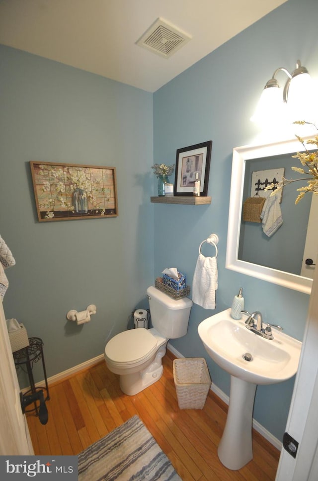 6385 Hunters Crossing Ct, Eldersburg, MD 21784 - half bath featuring wood finished floors, toilet, and baseboards