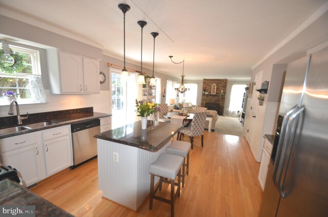 6385 Hunters Crossing Ct, Eldersburg, MD 21784 - kitchen featuring appliances with stainless steel finishes, a sink, white cabinetry, open floor plan, and a kitchen island