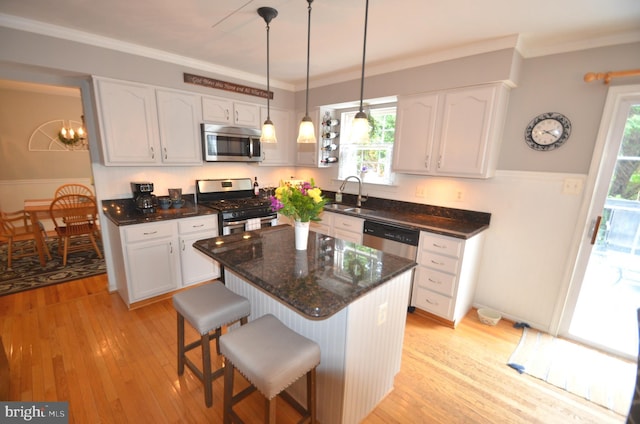 6385 Hunters Crossing Ct, Eldersburg, MD 21784 - kitchen with appliances with stainless steel finishes, a sink, white cabinetry, light wood-type flooring, and ornamental molding