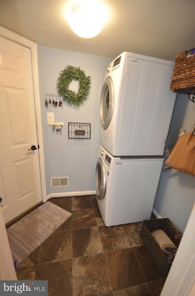 6385 Hunters Crossing Ct, Eldersburg, MD 21784 - laundry room featuring stacked washing machine and dryer, baseboards, and dark stone finish floors