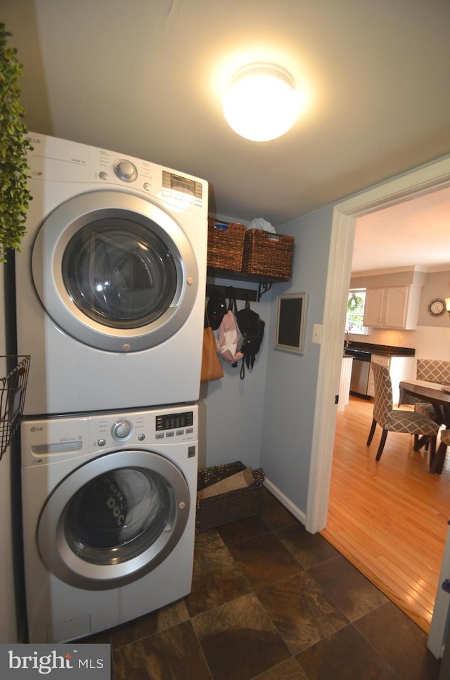6385 Hunters Crossing Ct, Eldersburg, MD 21784 - laundry room featuring stacked washer / dryer, baseboards, and dark stone finish flooring