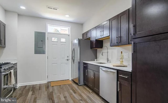 524 N Patterson Park Ave N, Baltimore, MD 21205 - kitchen featuring stainless steel appliances, electric panel, a sink, light wood-style flooring, and light countertops