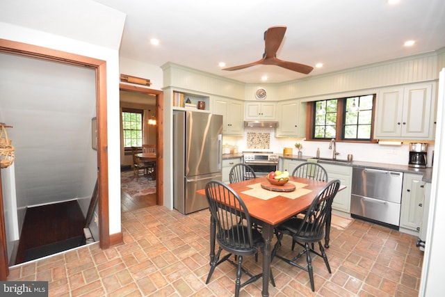 1598 Hollywood Dr, Lancaster, PA 17601 - kitchen with appliances with stainless steel finishes, brick patterned flooring, dark countertops, a sink, and under cabinet range hood