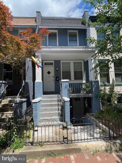 906 I St SE Unit 1, Washington, DC 20003 - view of front of house featuring brick siding, a fenced front yard, a porch, and stairs