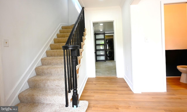 4504 Clay St NE, Washington, DC 20019 - staircase with stacked washing machine and dryer, wood finished floors, crown molding, and baseboards