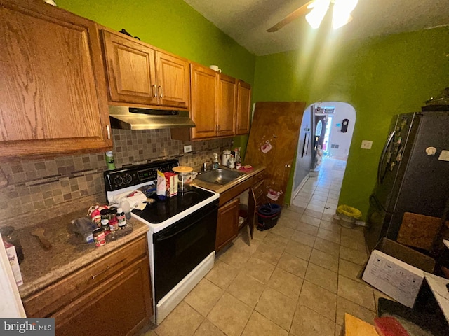 2844 N Hancock St, Philadelphia, PA 19133 - kitchen featuring under cabinet range hood, electric range oven, freestanding refrigerator, a sink, and backsplash