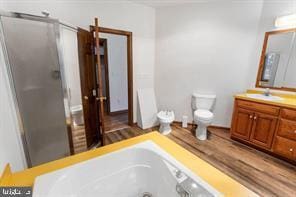 401 Fulton St, Hanover, PA 17331 - bathroom with vanity, a stall shower, toilet, a tub with jets, and wood finished floors