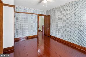 401 Fulton St, Hanover, PA 17331 - spare room featuring baseboards, wallpapered walls, wood finished floors, and a ceiling fan