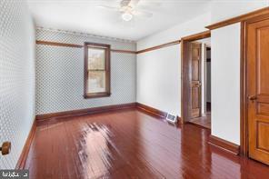 401 Fulton St, Hanover, PA 17331 - empty room featuring baseboards, hardwood / wood-style floors, ceiling fan, and wallpapered walls