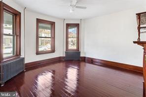 401 Fulton St, Hanover, PA 17331 - unfurnished room with radiator, wood finished floors, baseboards, and a ceiling fan