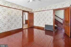 401 Fulton St, Hanover, PA 17331 - spare room with wallpapered walls, wood finished floors, a ceiling fan, and baseboards