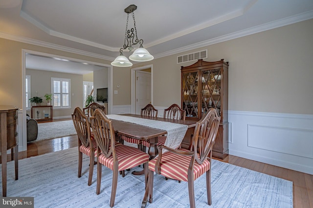 4408 Irish Creek Rd, Bernville, PA 19506 - dining room featuring a tray ceiling, wood finished floors, a wainscoted wall, and ornamental molding