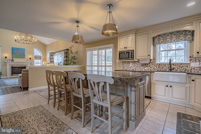4408 Irish Creek Rd, Bernville, PA 19506 - kitchen with stainless steel microwave, cream cabinetry, a sink, plenty of natural light, and lofted ceiling